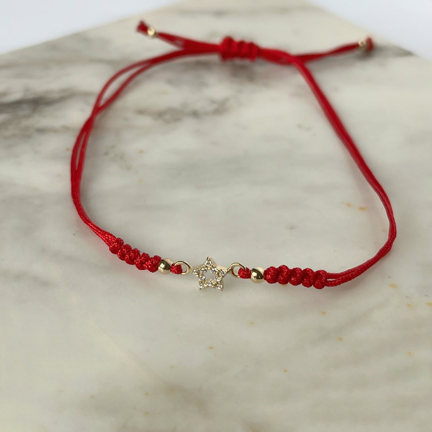 Pulsera cordón rojo estrella vacía en oro de 14K