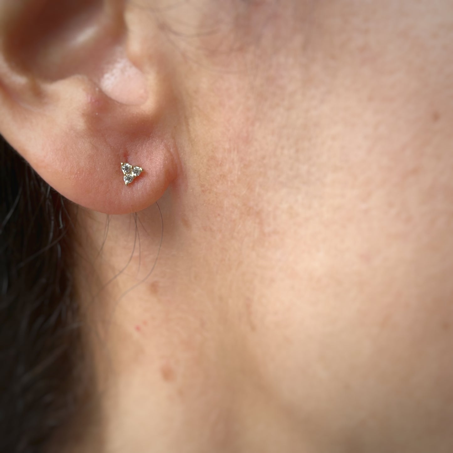 Aretes tres circonitas blancas mini en oro de 14k con tope ortopédico