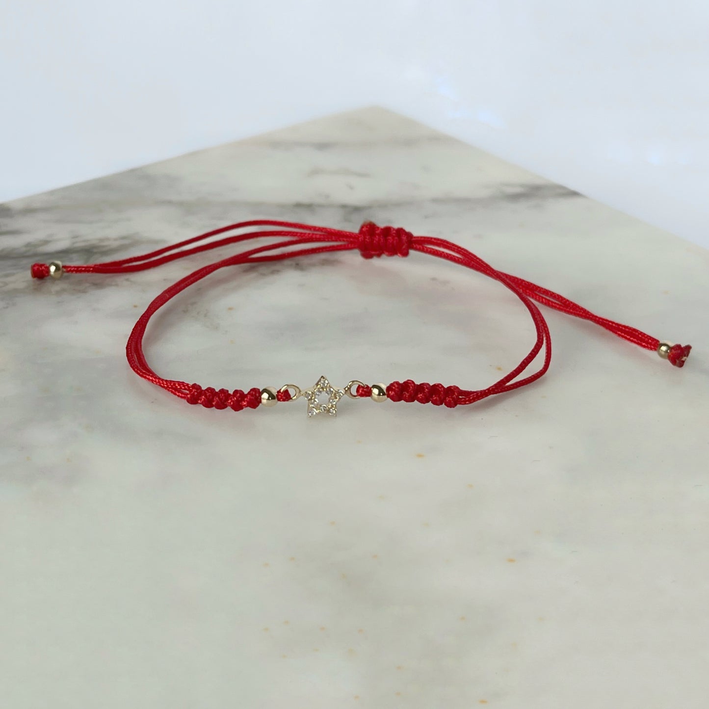 Pulsera cordón rojo estrella vacía en oro de 14K