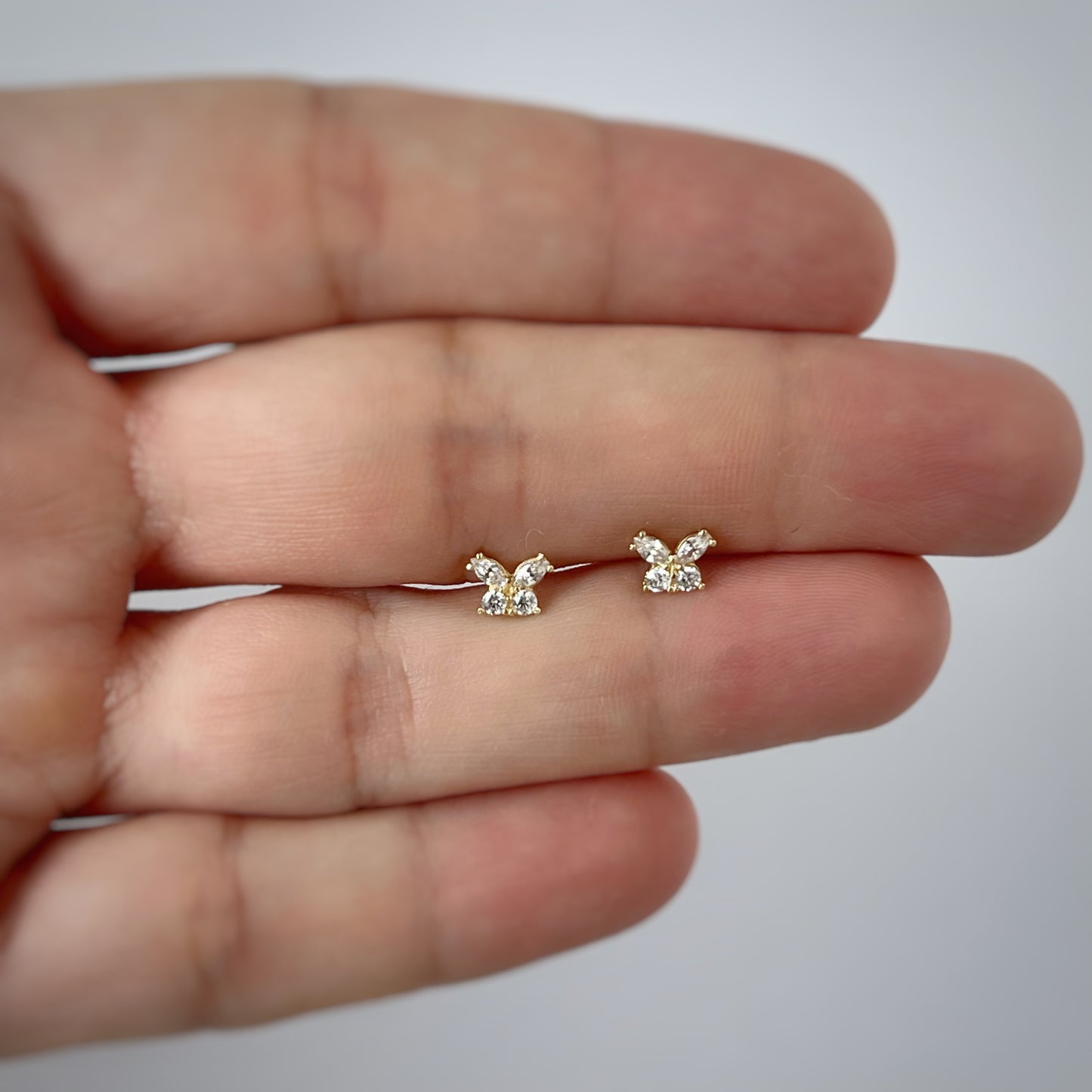 Aretes mariposa circonita blancos en oro amarillo de 14k con tope ortopédico