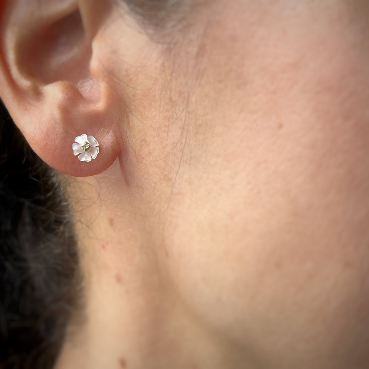 Aretes con cinco pétalos de madre perla y circonita en el centro en oro amarillo de 14k con tope ortopédico