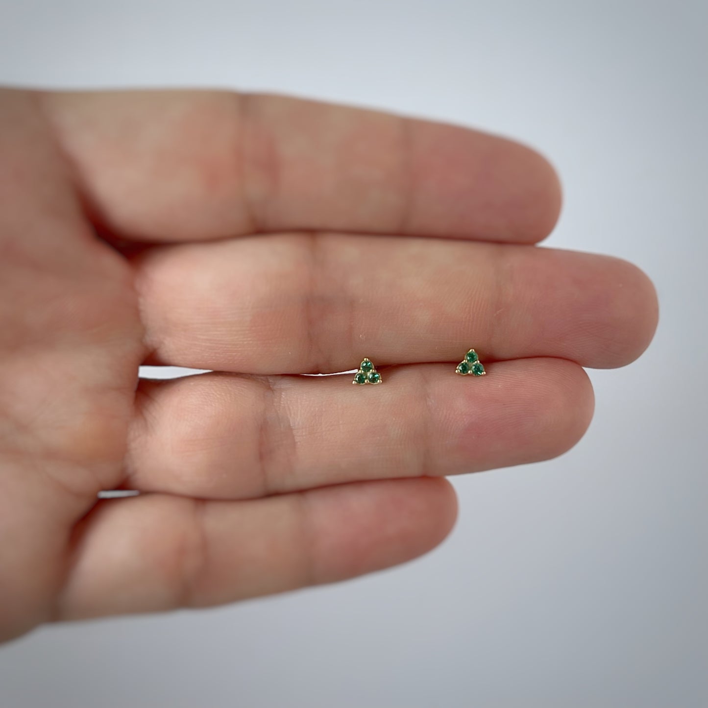 Aretes tres circonitas verdes mini en oro de 14k con tope ortopédico