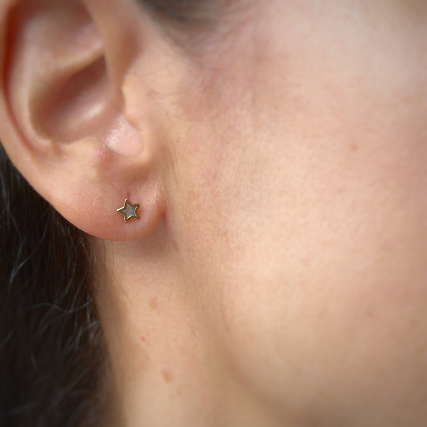 Aretes estrella con centro de madre perla y filo de oro amarillo de 14k