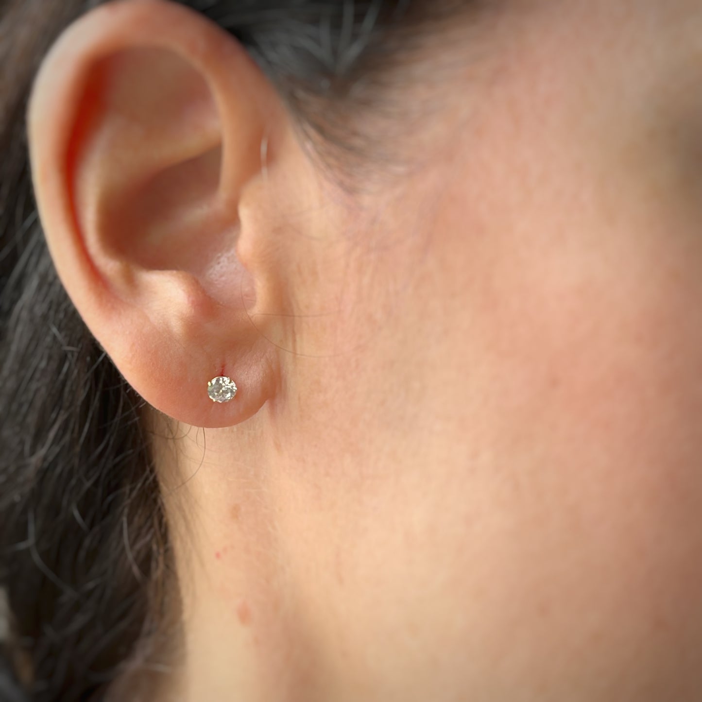Arete con circonita redonda blanca en oro amarillo de 14k con tope ortopédico