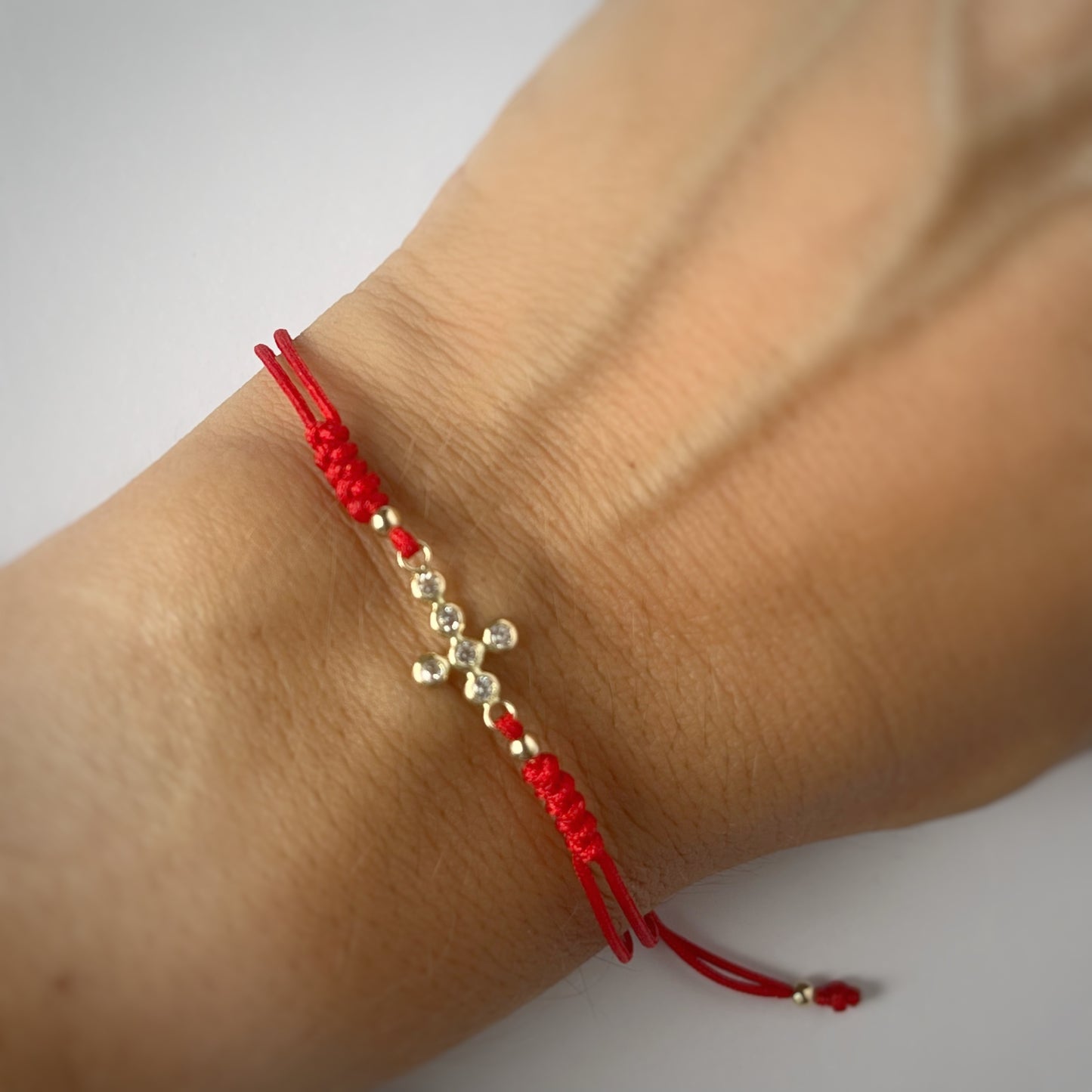 Pulsera cordón rojo cruz en oro de 14K