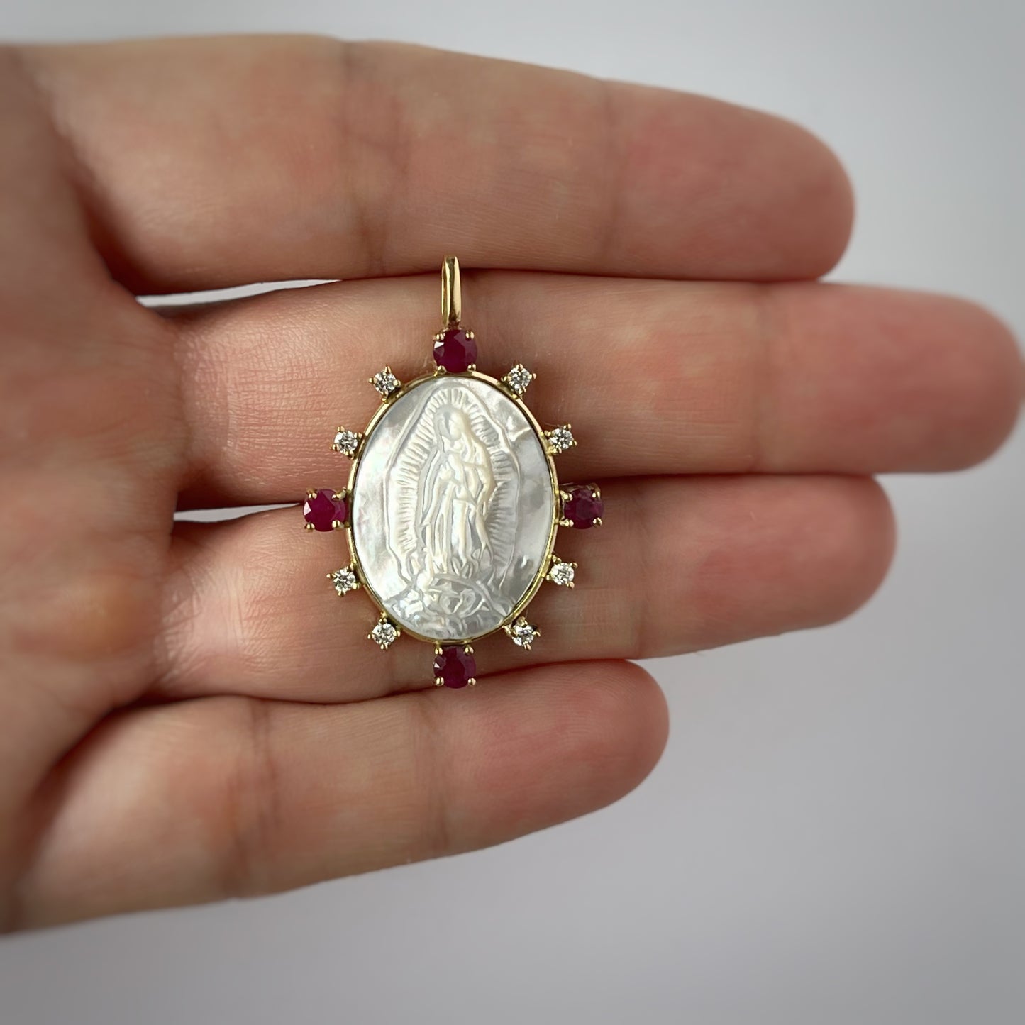 Medalla de la virgen de guadalupe de madre perla con borde de oro 18k con rubíes y diamantes