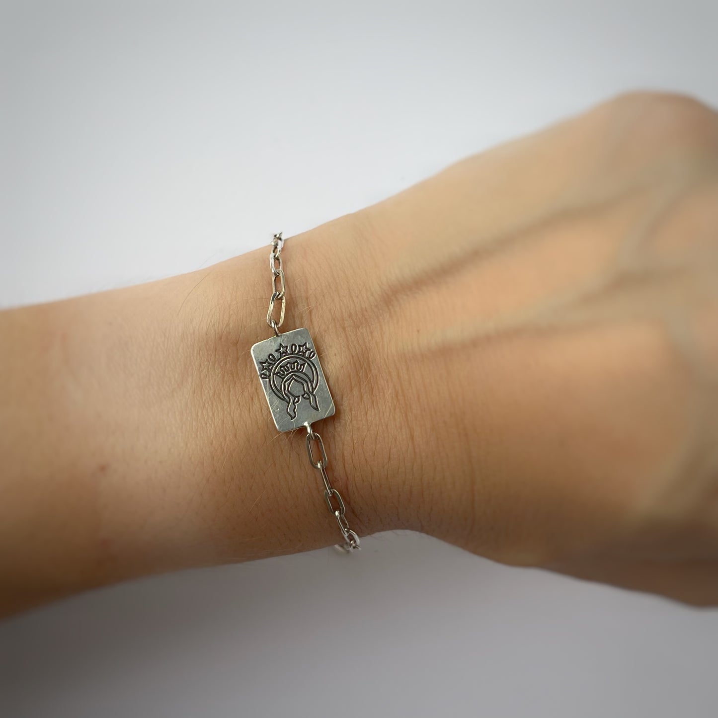Pulsera paperclip con escapulario rectangular en plata