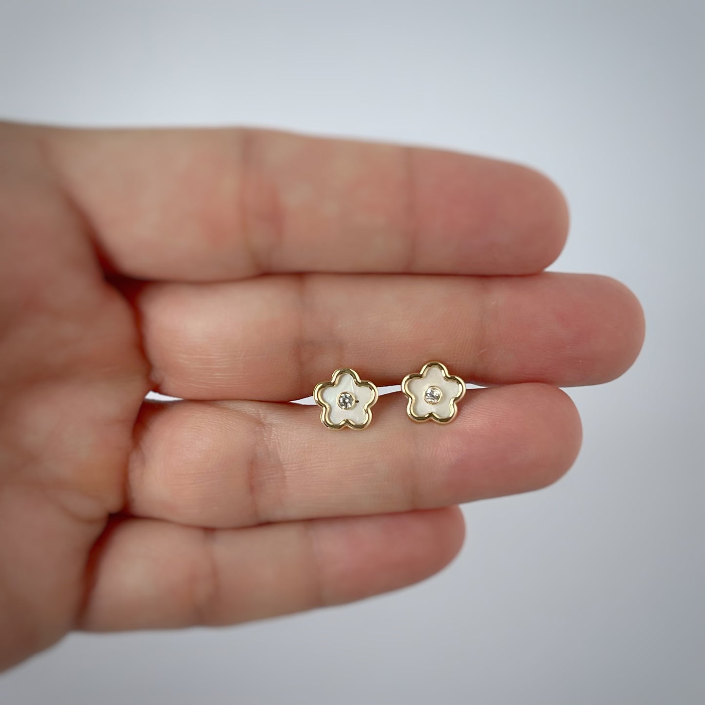 Aretes flor en madre perla con circonita blanca en el centro y filo de oro de 14k con tope ortopédico