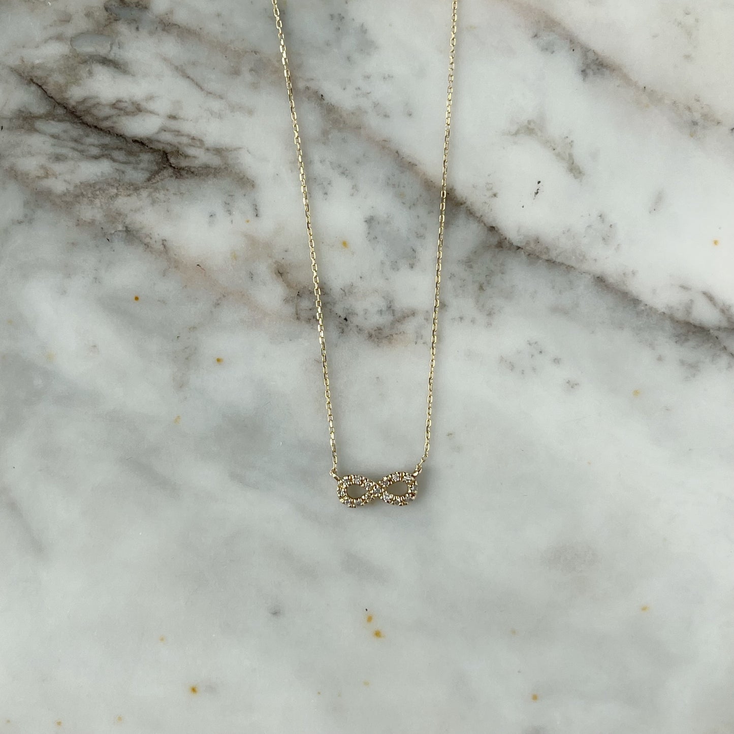 Collar en oro amarillo 14k con infinito de diamantes 0.05ctw