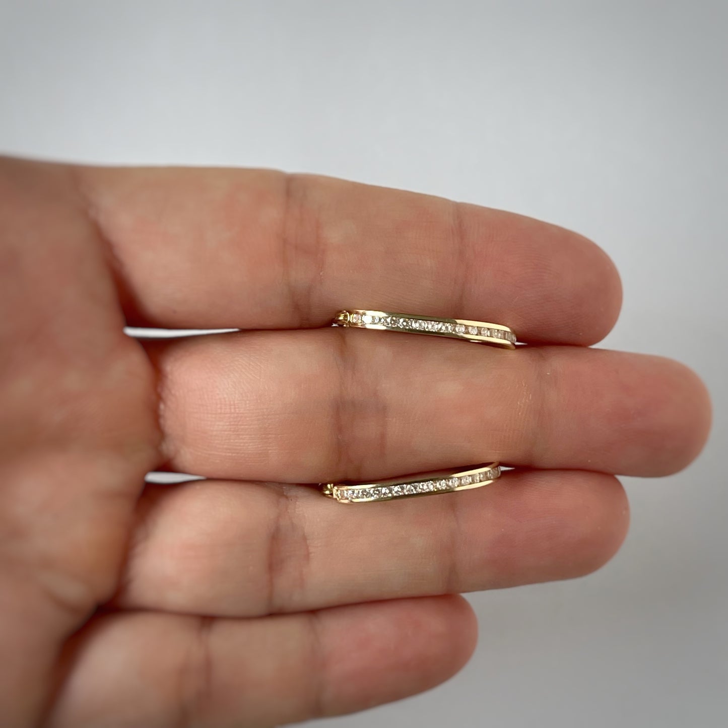 Argollas ovaladas con circonitas en oro amarillo 14k