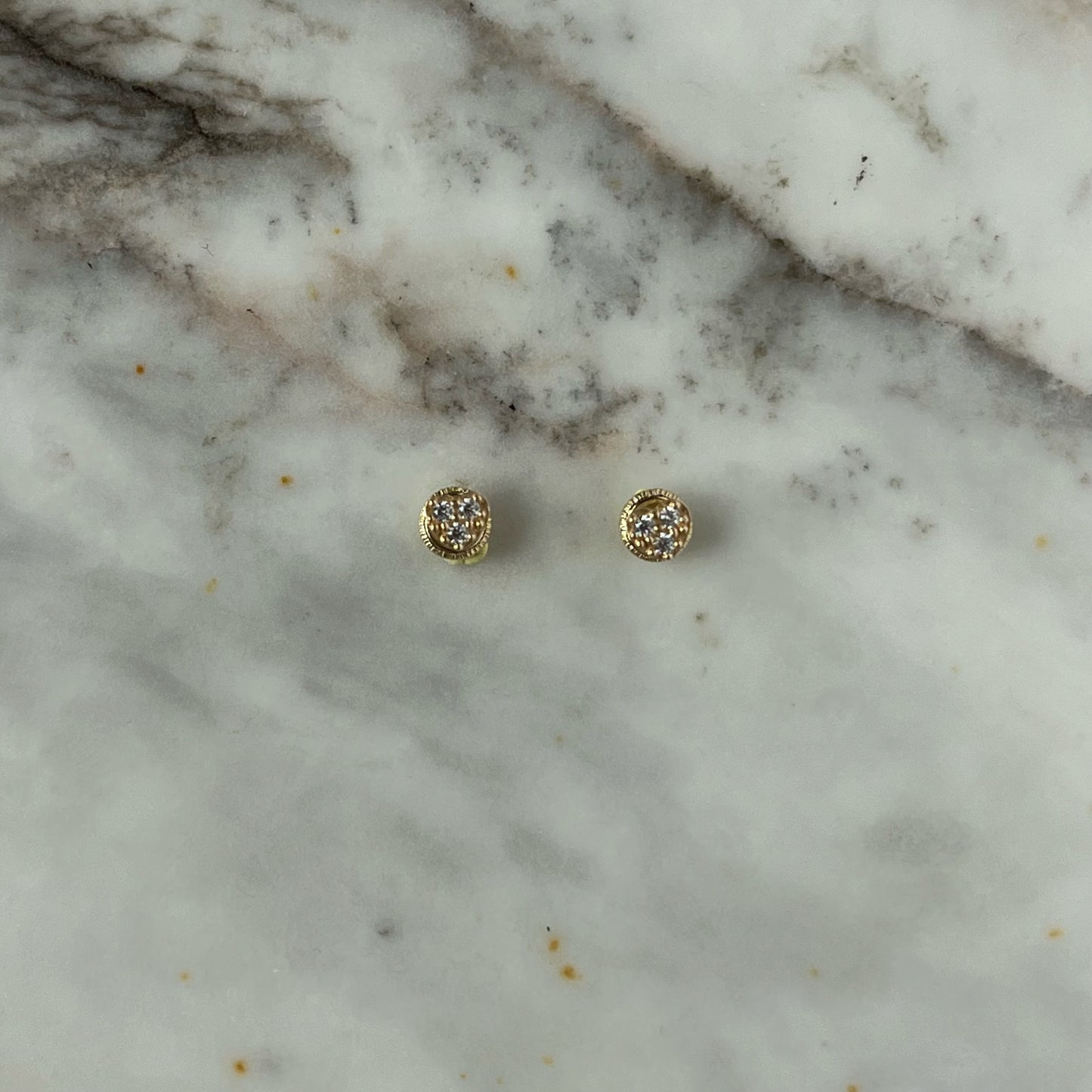Aretes en forma de corazón con tres circonitas blancas en oro de 14k con tope ortopédico
