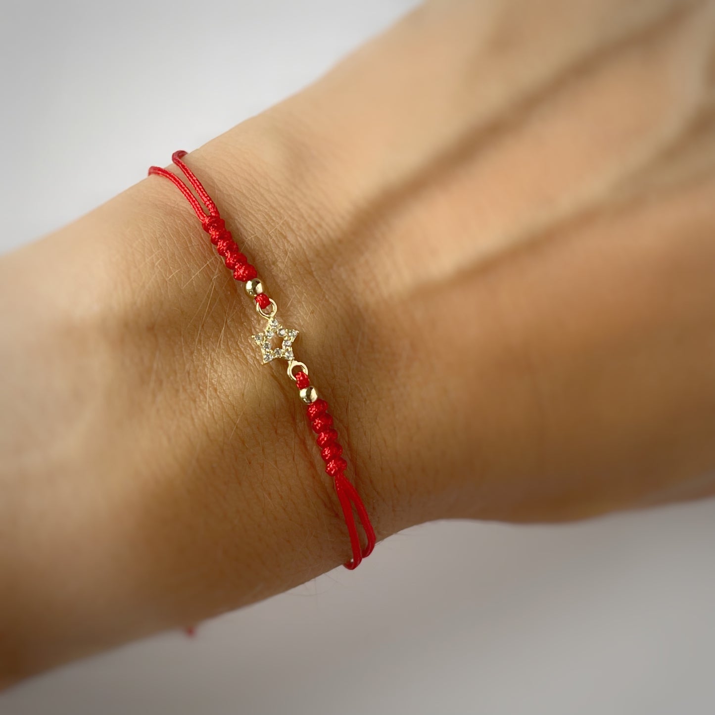 Pulsera cordón rojo estrella vacía en oro de 14K
