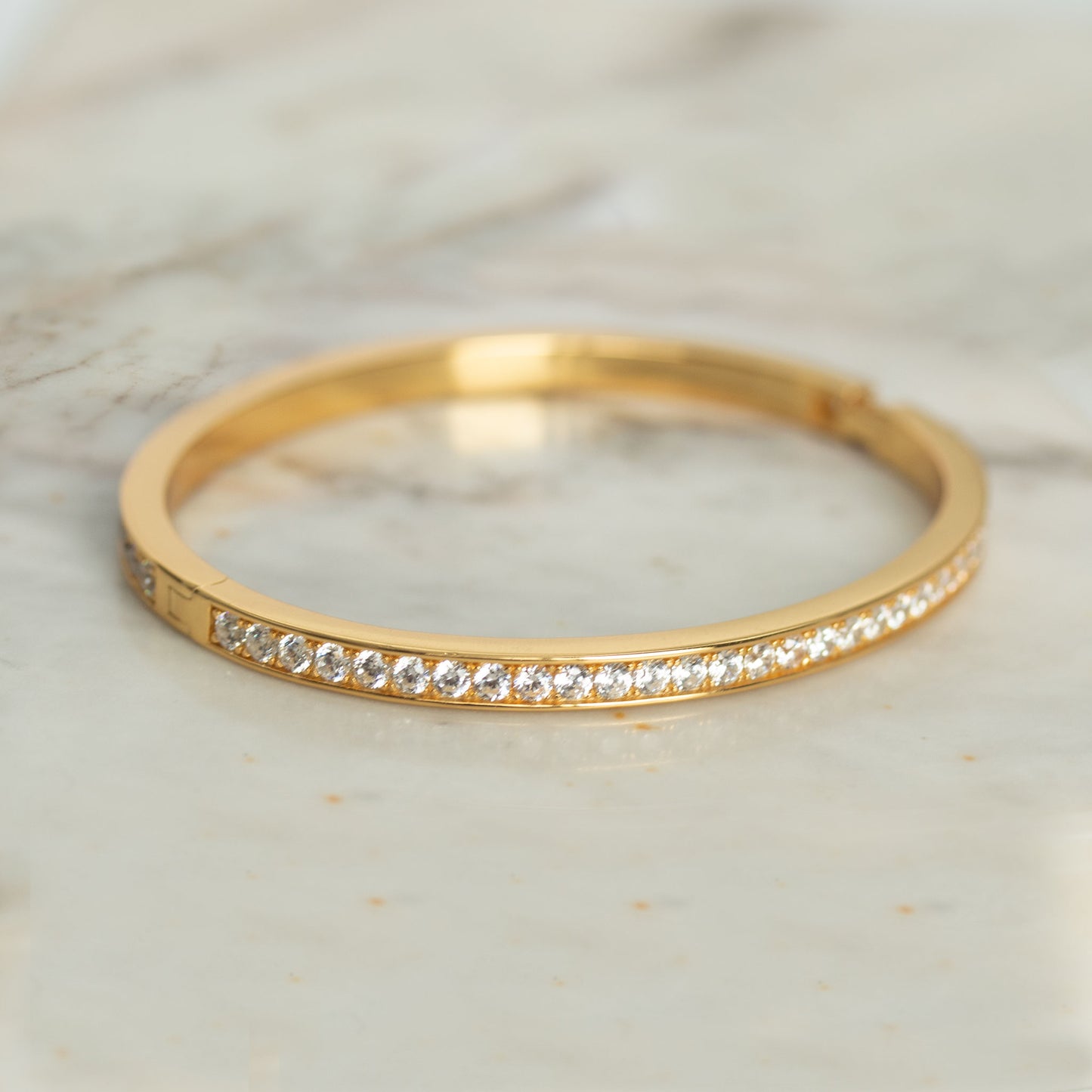 Pulsera dura en plata con baño de oro amarillo y circonitas