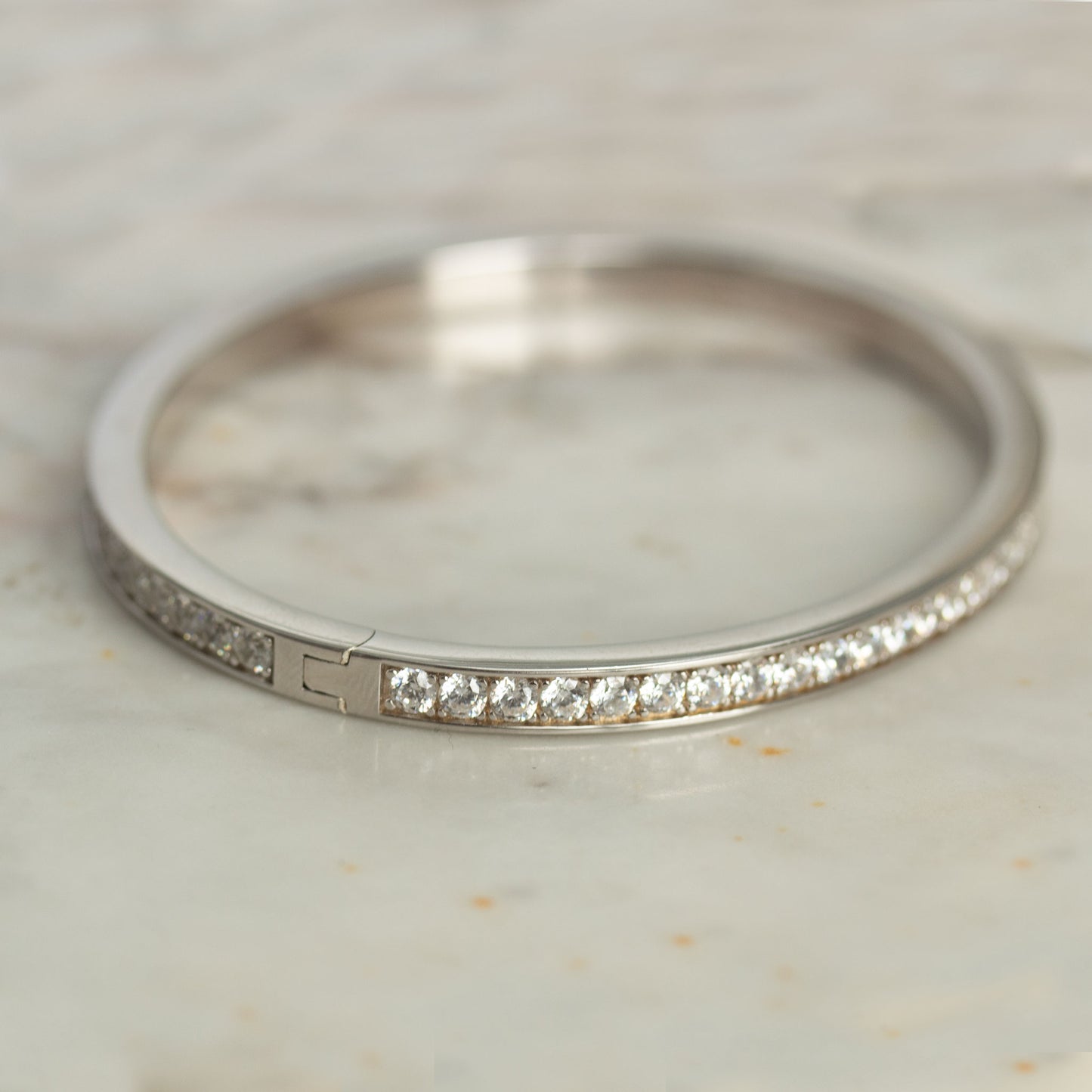 Pulsera dura en plata con baño de platino y circonitas