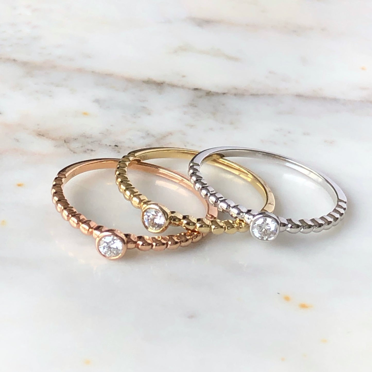 Anillo de bolitas y diamante biselado en oro de 14k