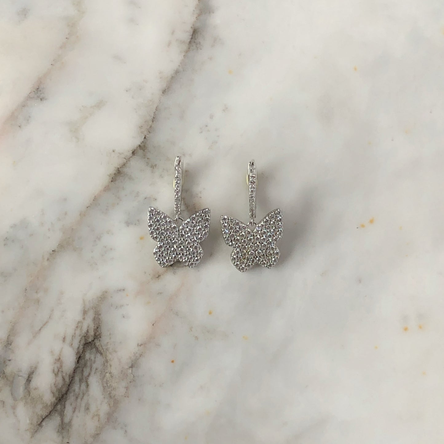 Argollas con mariposa de cz en płata con baño de platino