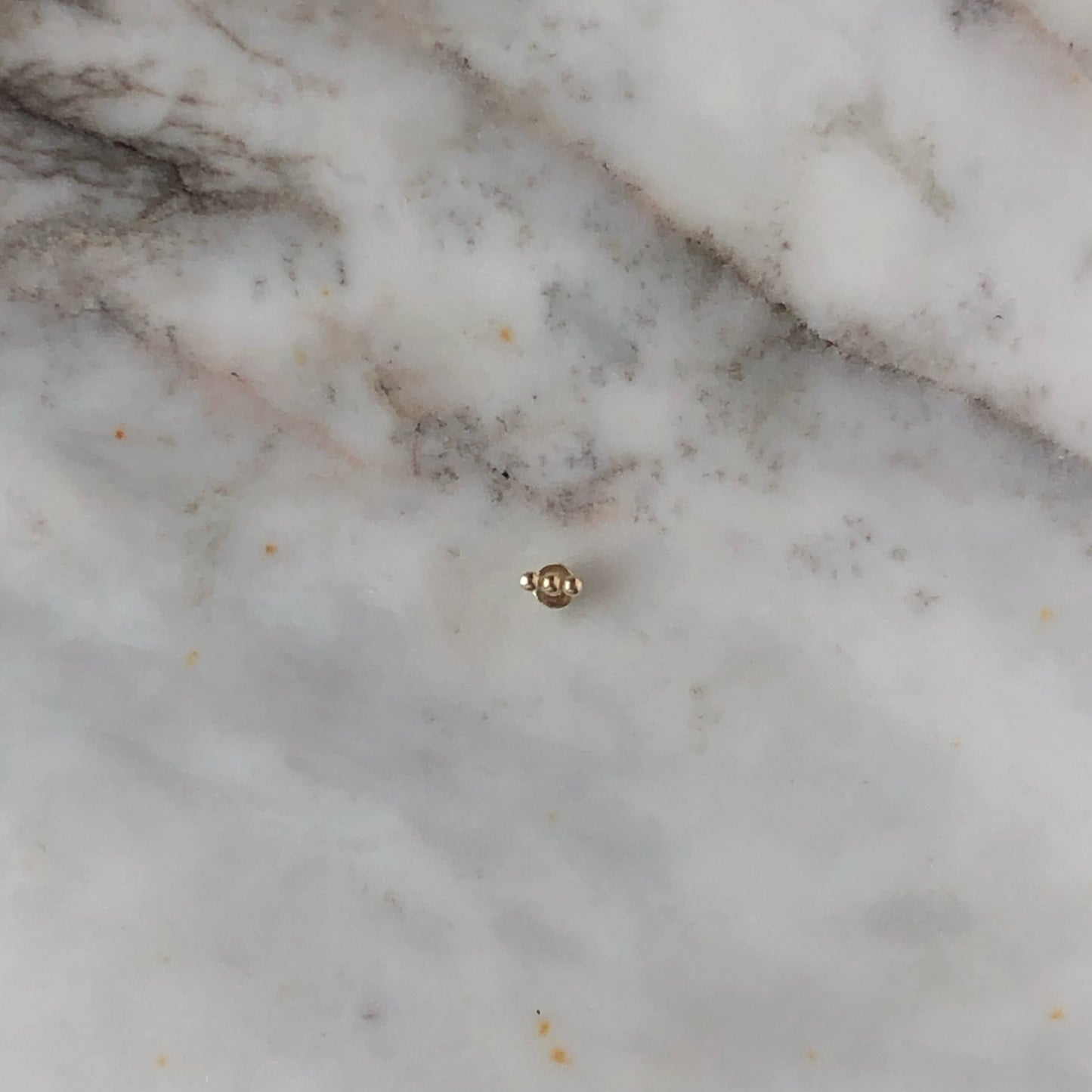 Aretes single en oro amarillo 14k de 3 bolitas y rosca interna para piercing