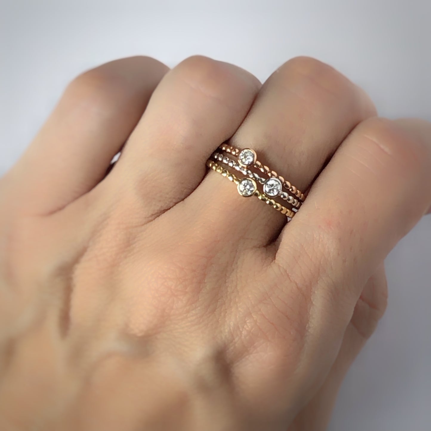 Anillo de bolitas y diamante biselado en oro de 14k