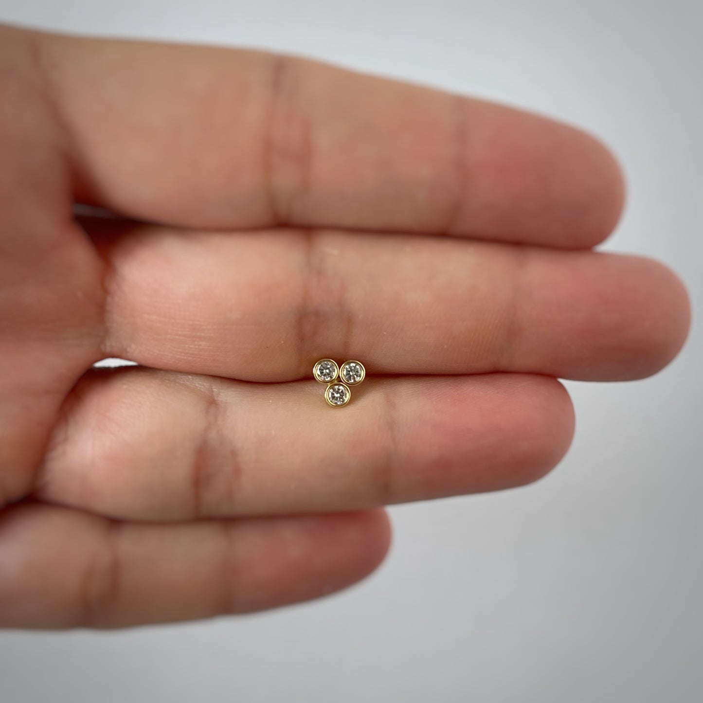 Arete piercing single de 3 circonitas biseladas en oro amarillo de 14 k