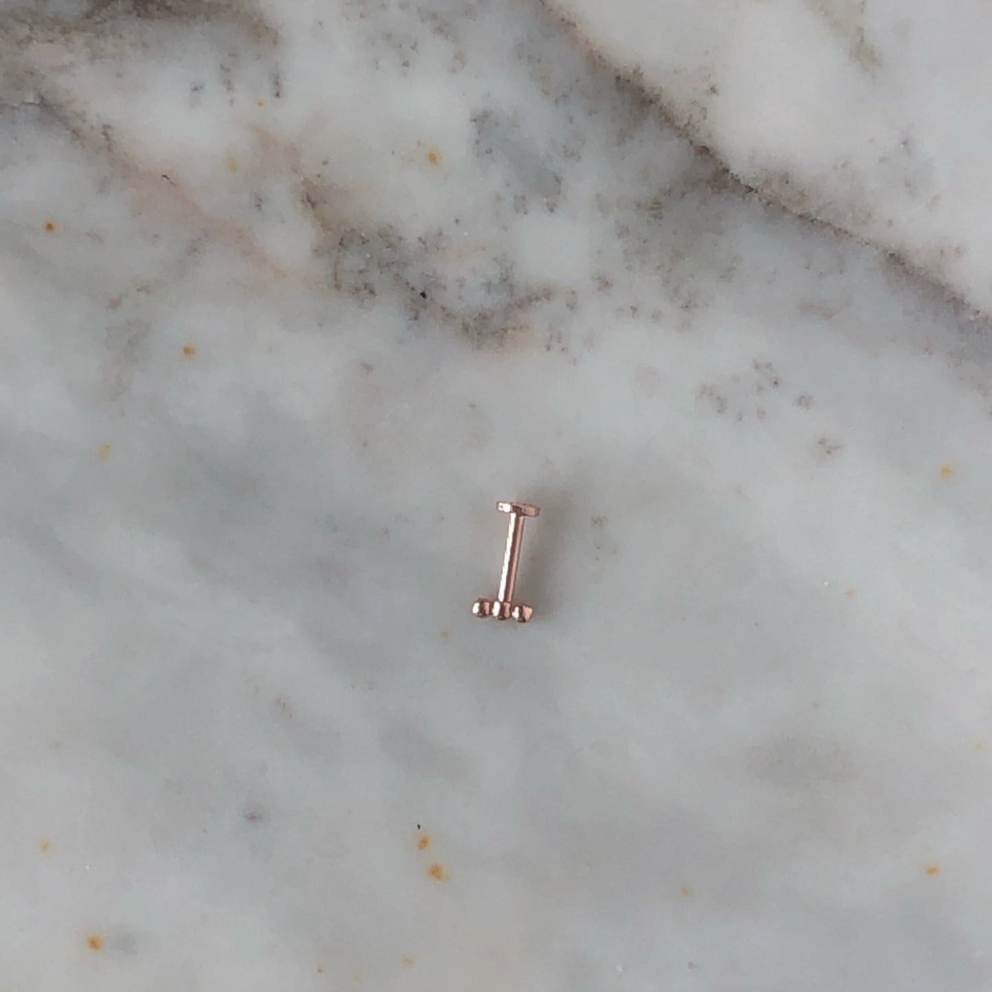 Aretes single en oro rosa 14k de 3 bolitas y rosca interna para piercing