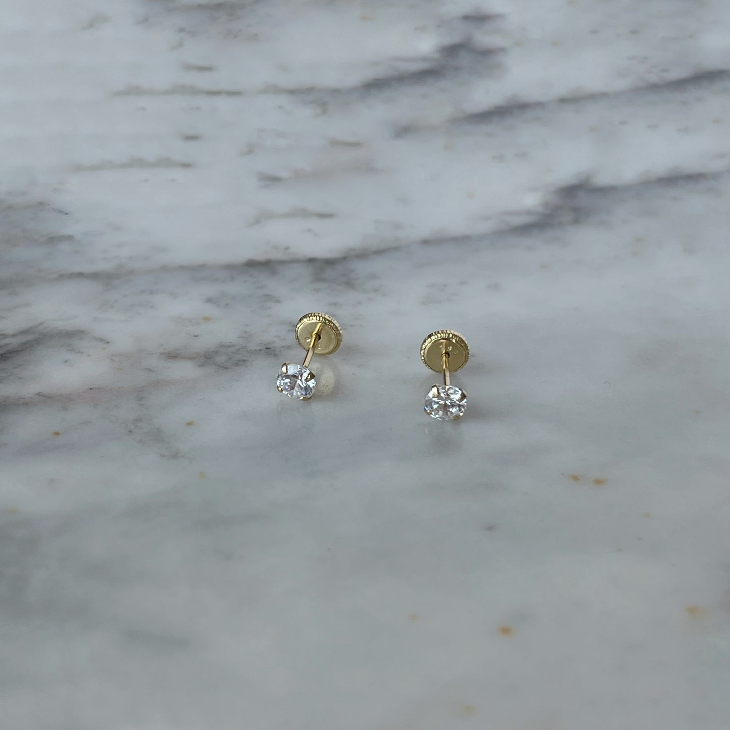 Aretes en oro amarillo de 18K con circonita blanca de 5mm con topa rosca