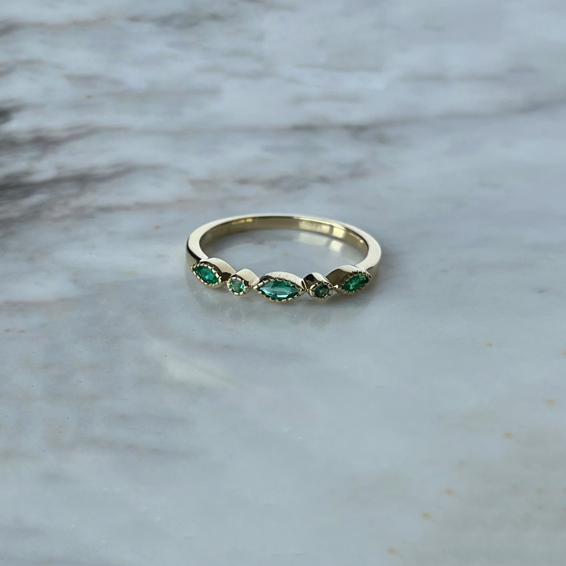 Anillo en oro amarillo 10k con esmeralda, marquesas y redondas