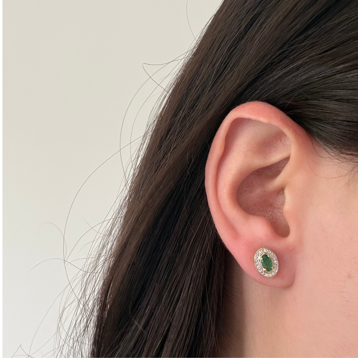 Aretes en oro amarillo 10K con esmeralda ovalada y halo de diamantes 0.05ctw
