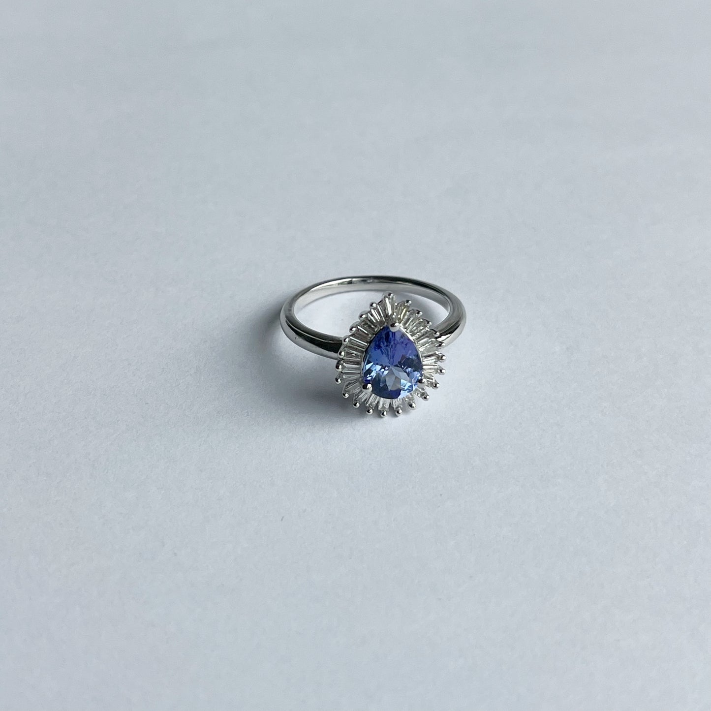 Anillo de oro blanco 10K con tanzanita corte pera y halo de diamantes baguette 0.20ct