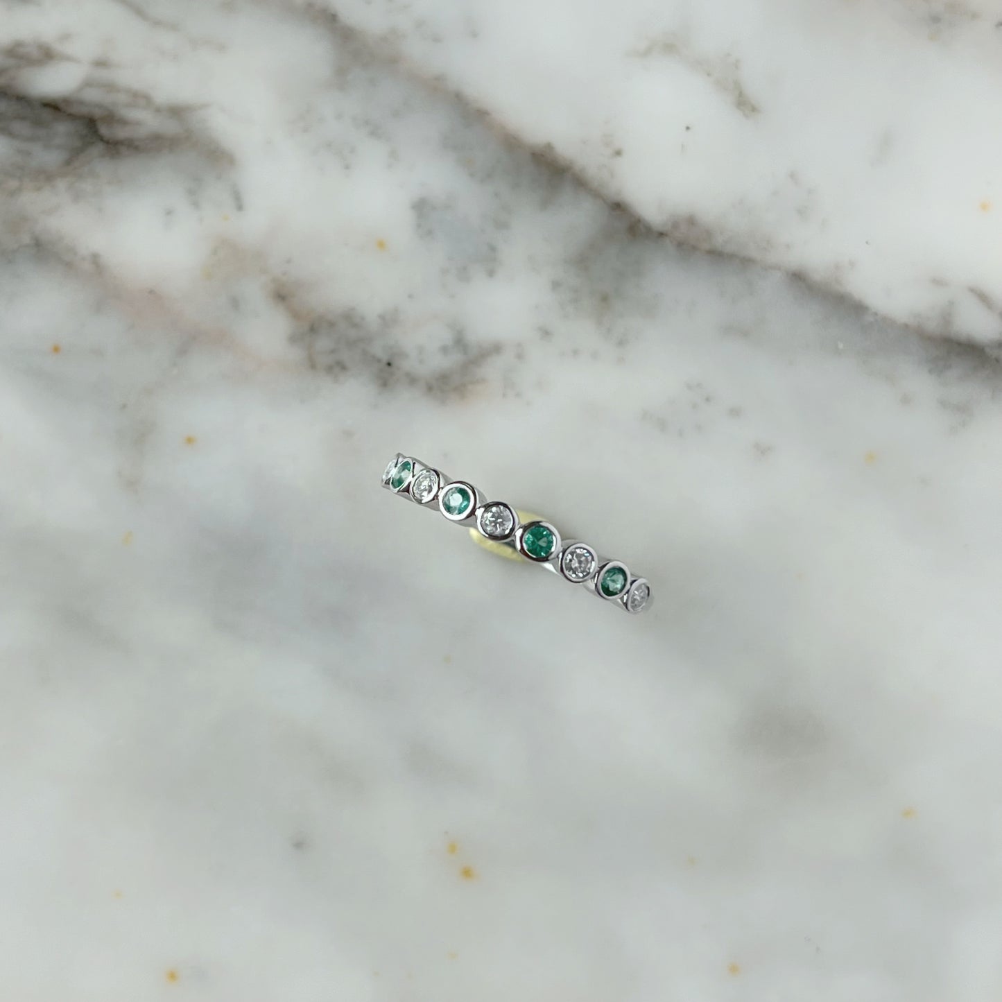 Medio cintillo de diamantes 0.15ctw y esmeraldas biseladas en oro blanco 10k