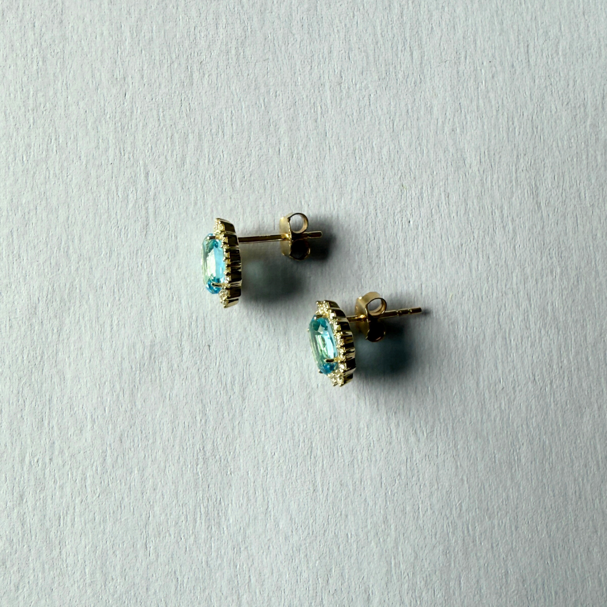 Aretes en oro amarillo 10k con topacios azules ovalados y halo de diamantes 0.35ctw