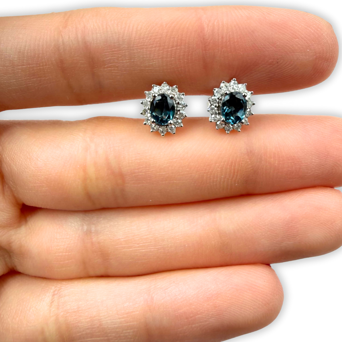 Aretes ovalados en oro blanco 10K con topacio london blue y halo de diamantes 0.25ctw