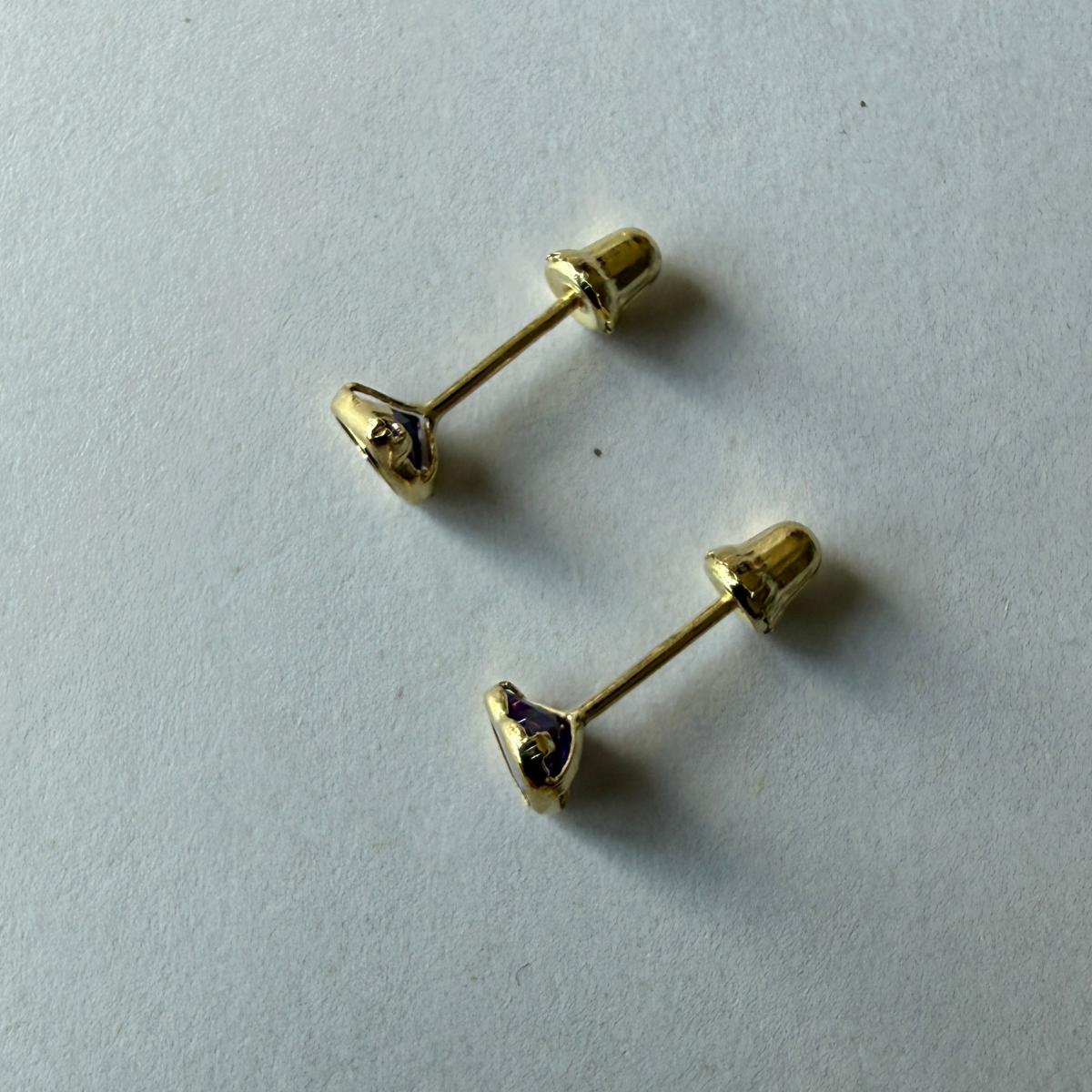 Aretes en oro amarillo 14k con corazón de circonita morada biselado con tope rosca