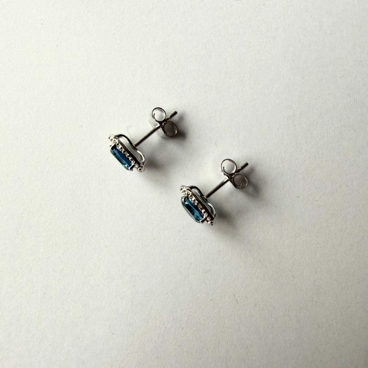 Aretes en oro blanco 10K con topacio london blue ovalado y halo de diamantes 0.09ctw