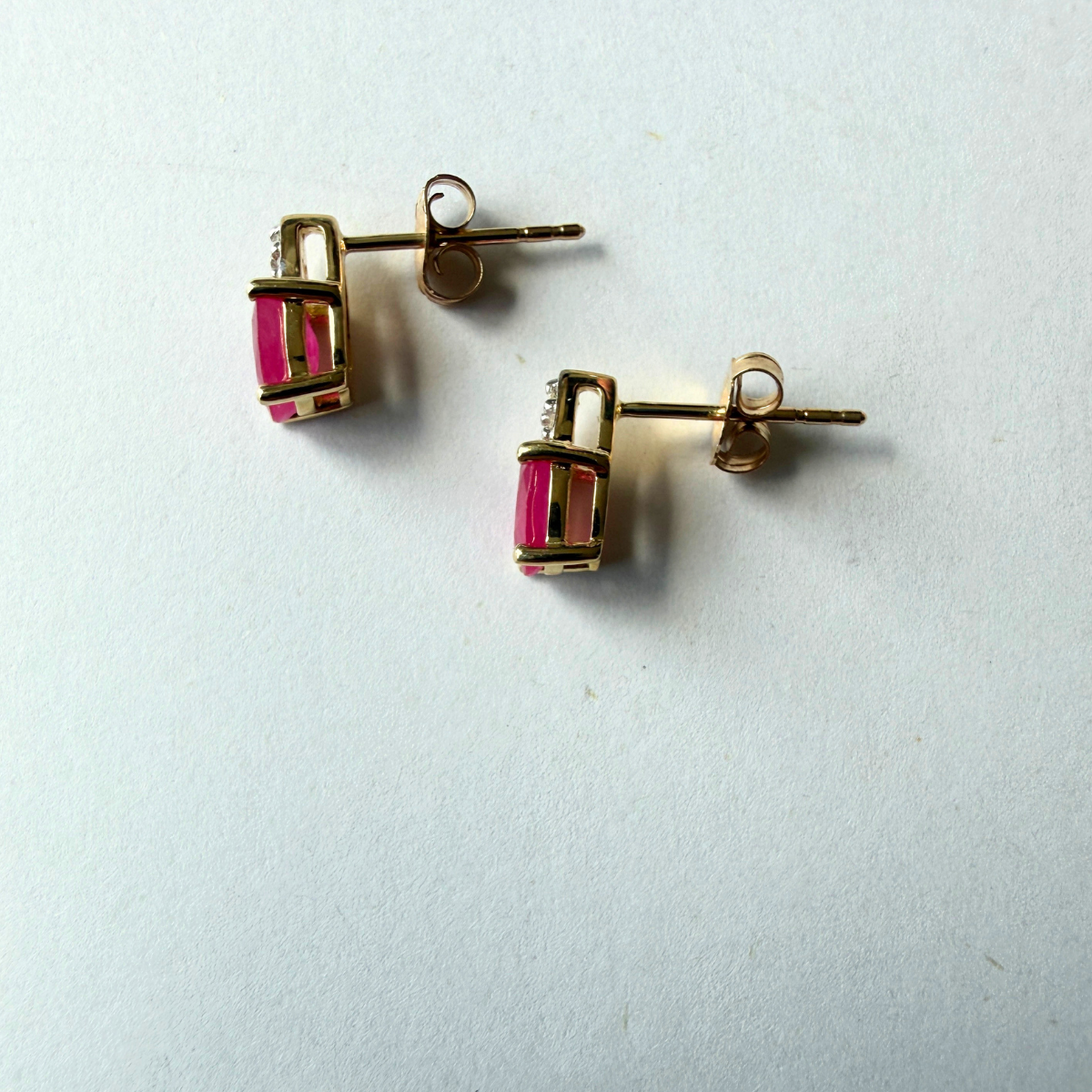 Aretes en oro amarillo 10k con rubí ovalado y 3 diamantes 0.03ctw.