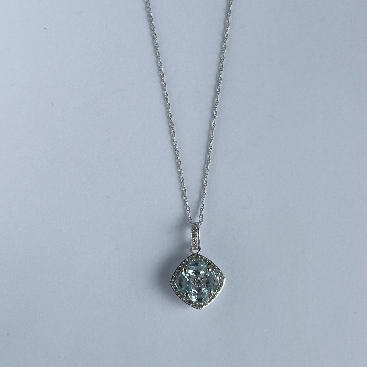 Collar en oro blanco 14k con dije de aquamarinas en forma de flor y borde de diamantes 0.15ctw