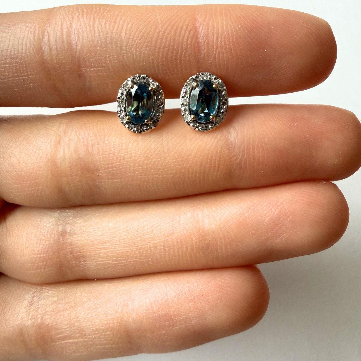 Aretes en oro amarillo 10K con topacio london blue ovalado y halo de diamantes 0.09ctw
