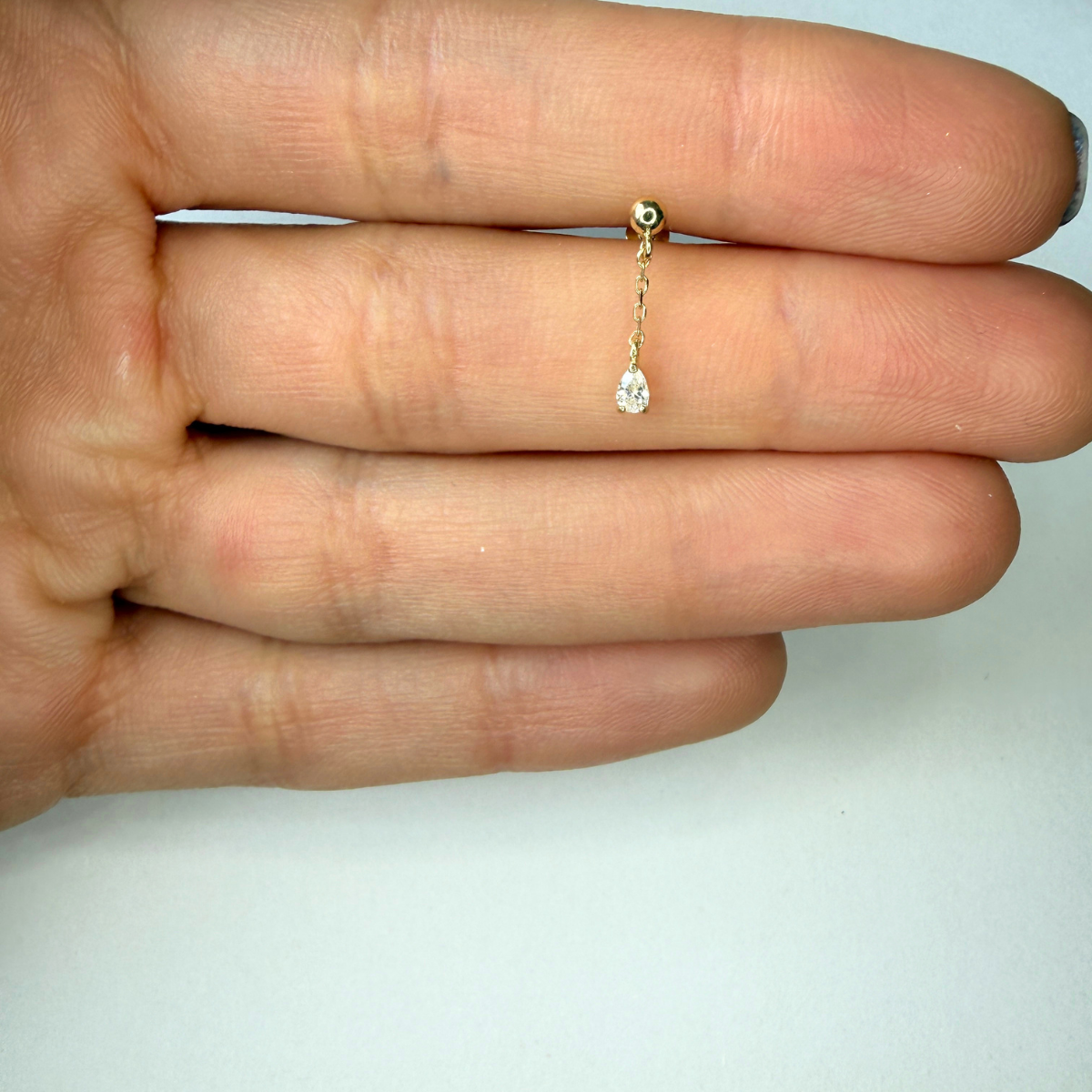 Arete piercing bolita de oro amarillo 14k con cadena y gota de circón colgando