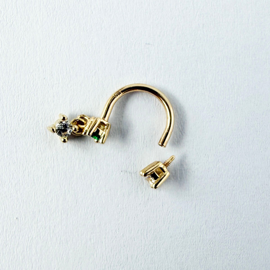 Arete piercing curva en oro amarillo 14k con circonitas blancas y verde