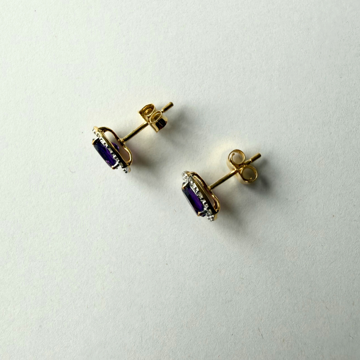 Aretes en oro amarillo 10K con amatista ovalada y halo de diamantes 0.09ctw