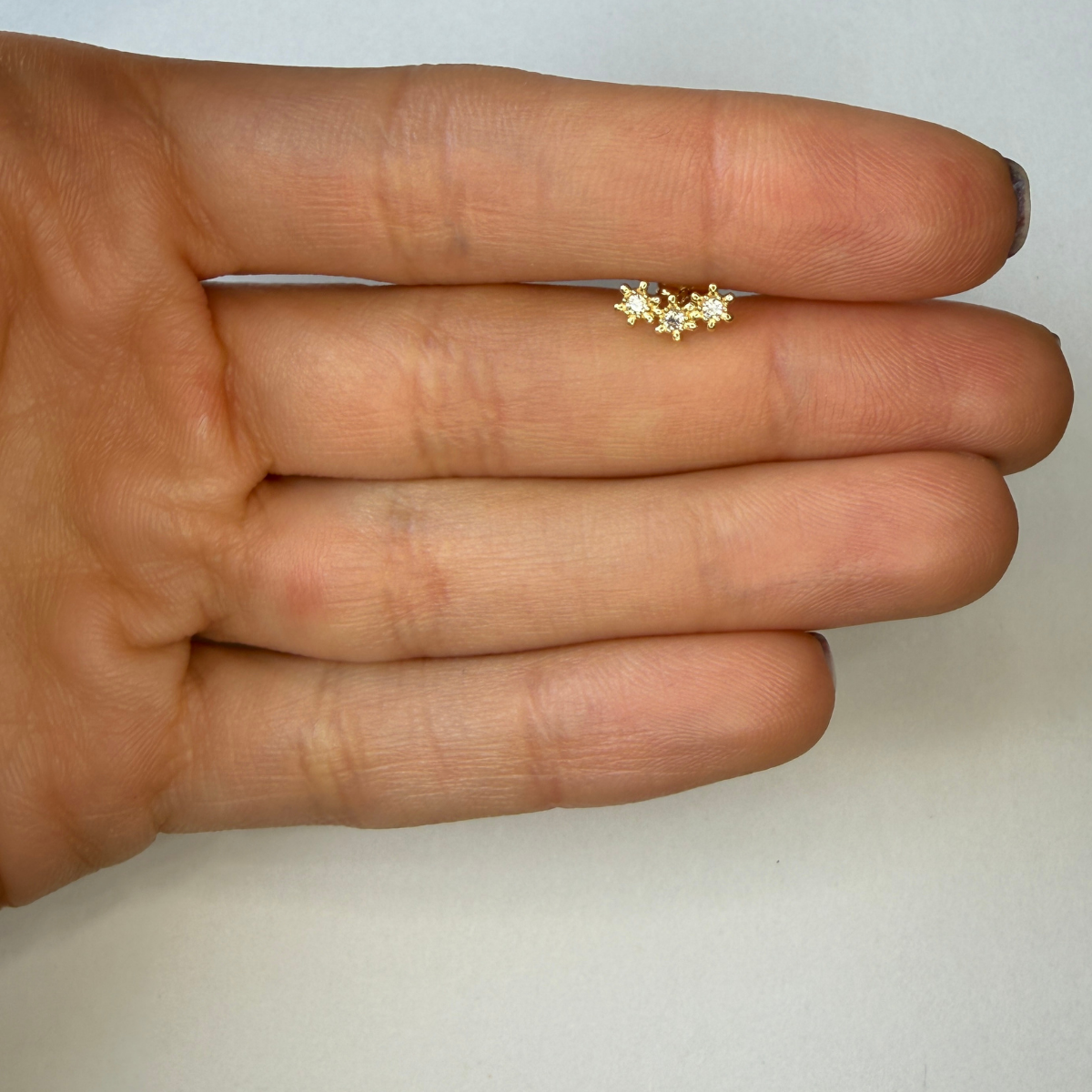 Arete en oro amarillo 14k con tres estrellas de circonitas blancas