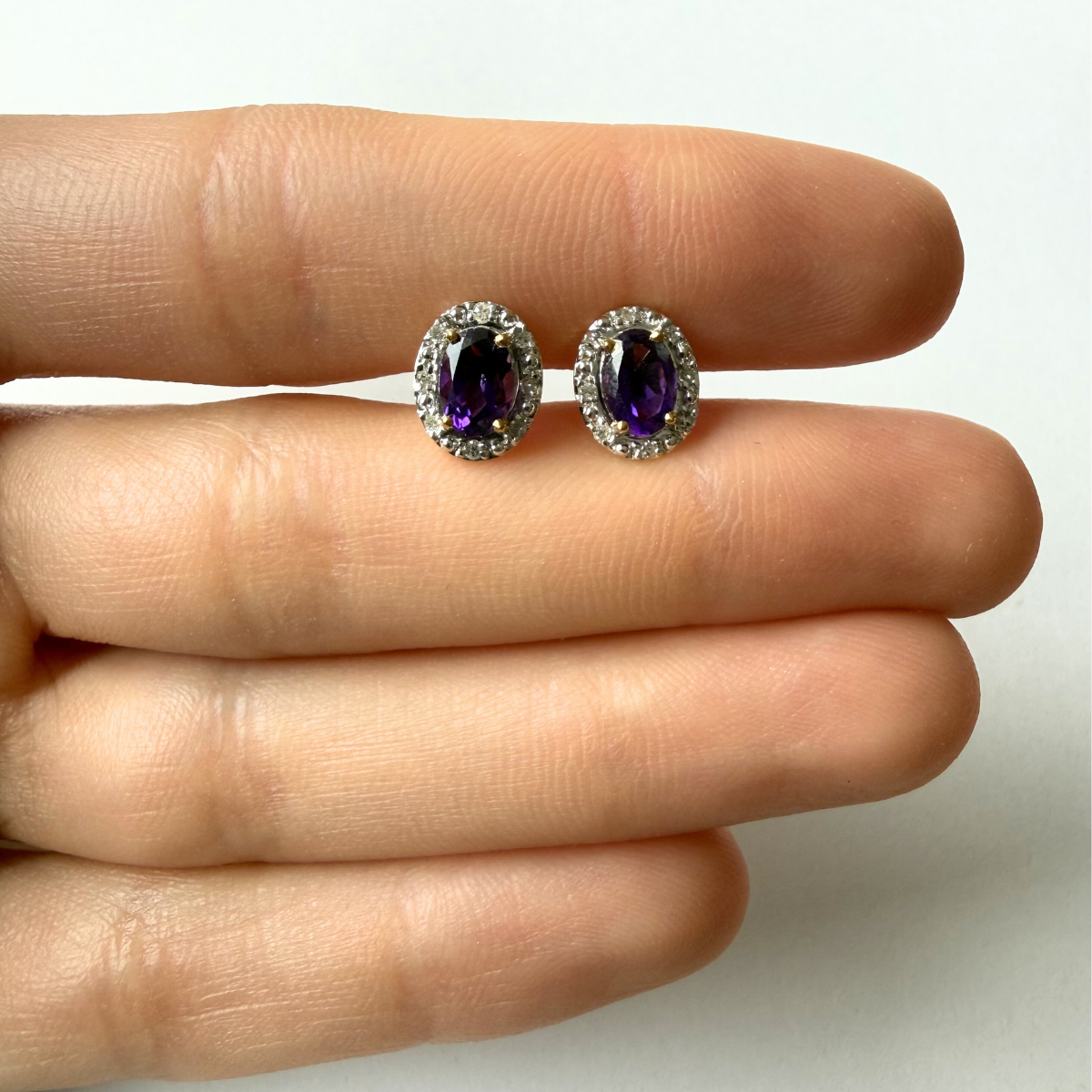 Aretes en oro amarillo 10K con amatista ovalada y halo de diamantes 0.09ctw