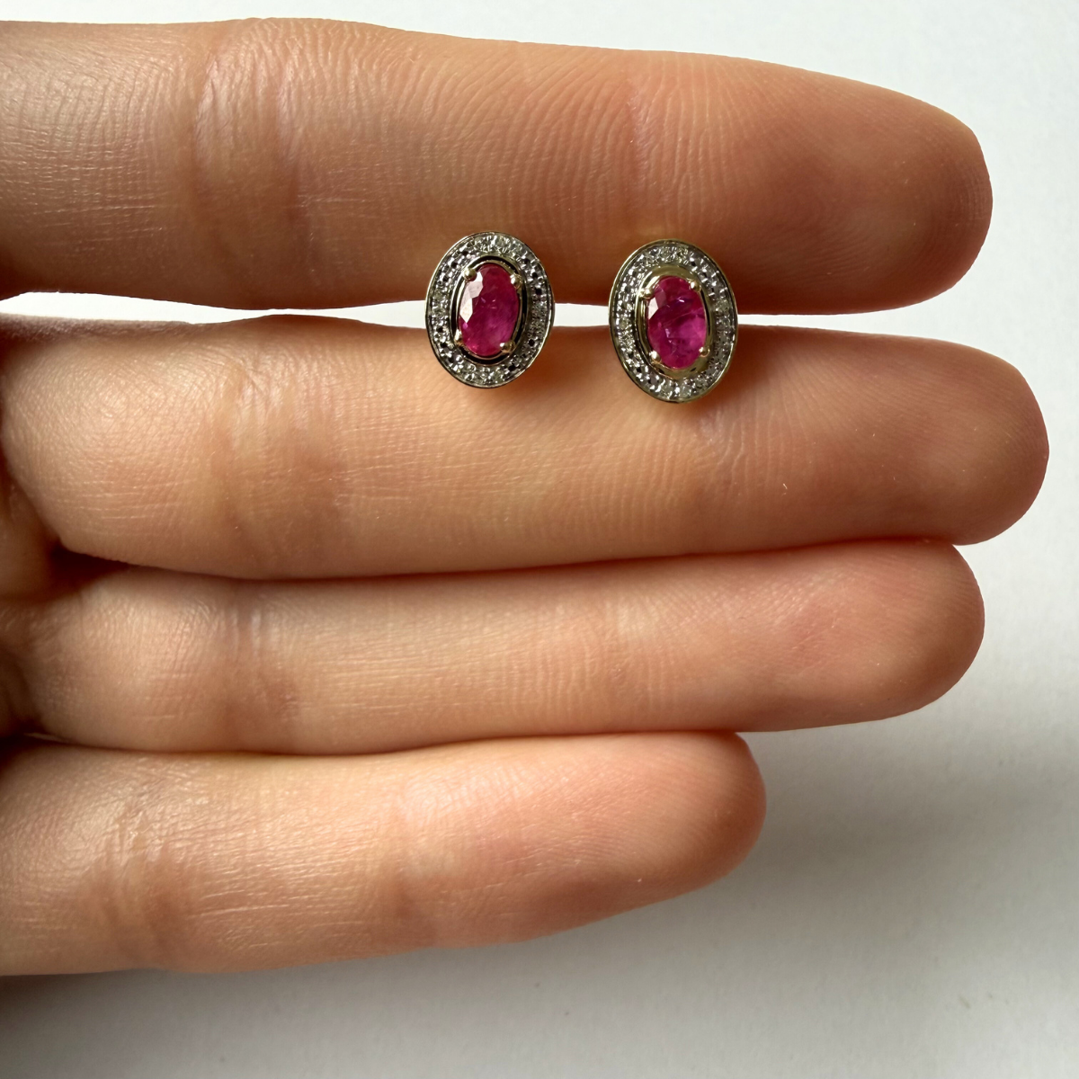 Aretes en oro amarillo 10K con rubí ovalado y halo de diamantes 0.05ctw