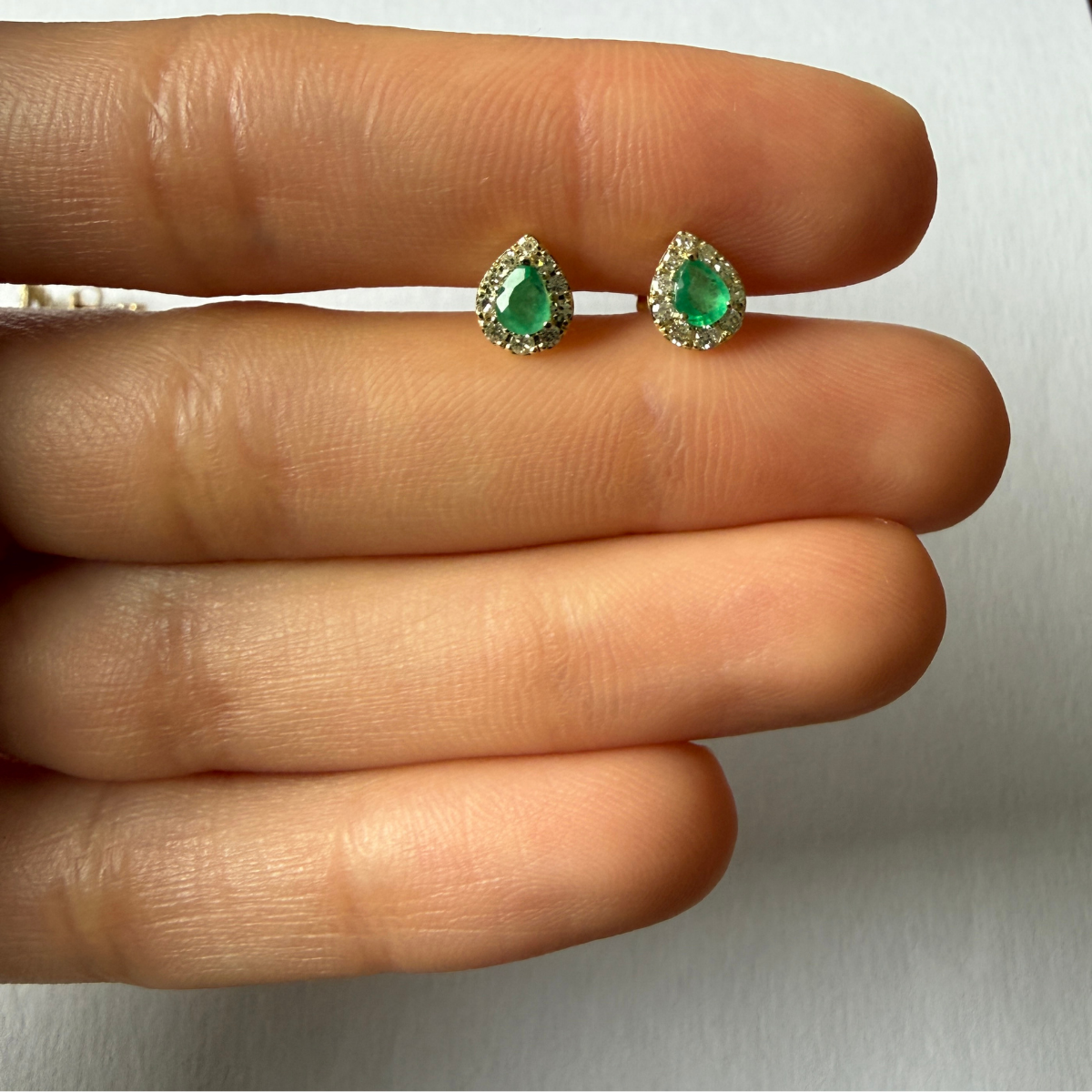 Aretes en oro amarillo 10k con esmeralda corte pera y halo de diamantes 0.18ctw