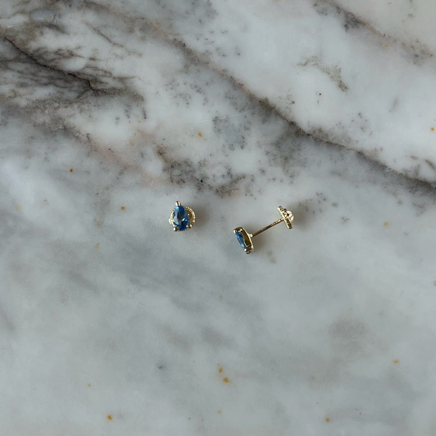 Aretes en oro amarillo 14K en forma de gota con circonita azul con tope rosca