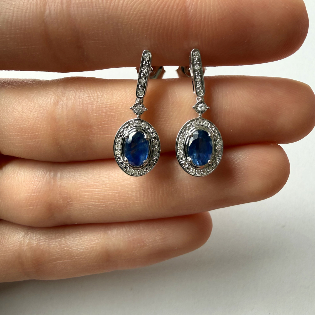 Aretes en oro blanco 10K con barrita de diamantes y colgante de zafiro ovalado con halo de diamantes 0.11ctw