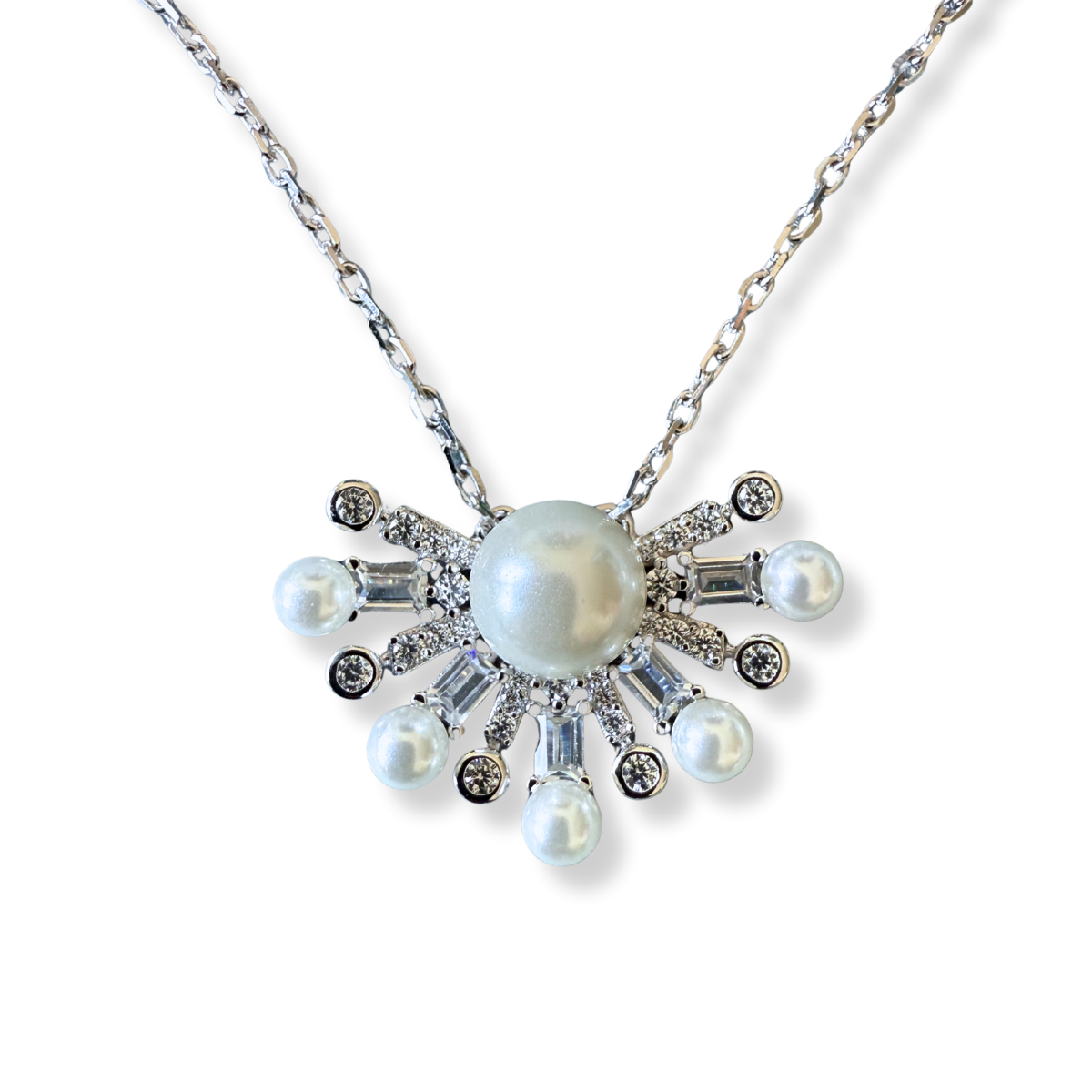 Collar de plata con baño platino y media flor de perla en el centro y circonitas blancas