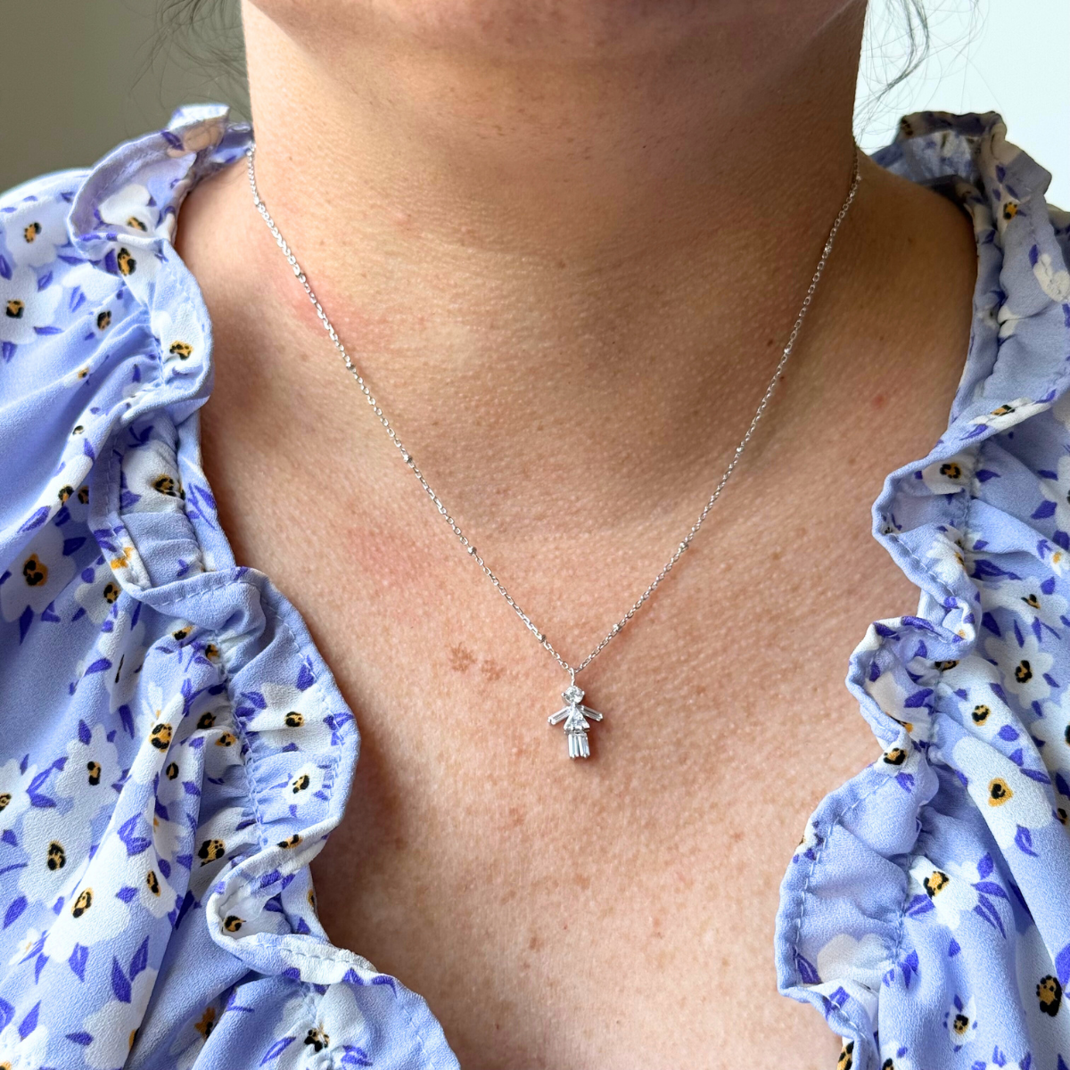 Collar de plata con baño platino y figura de niña con circones