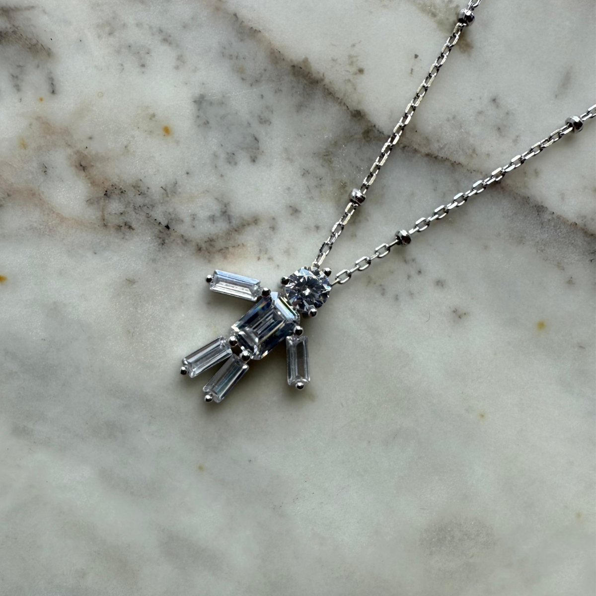 Collar de plata con baño platino y figura de niño con circones