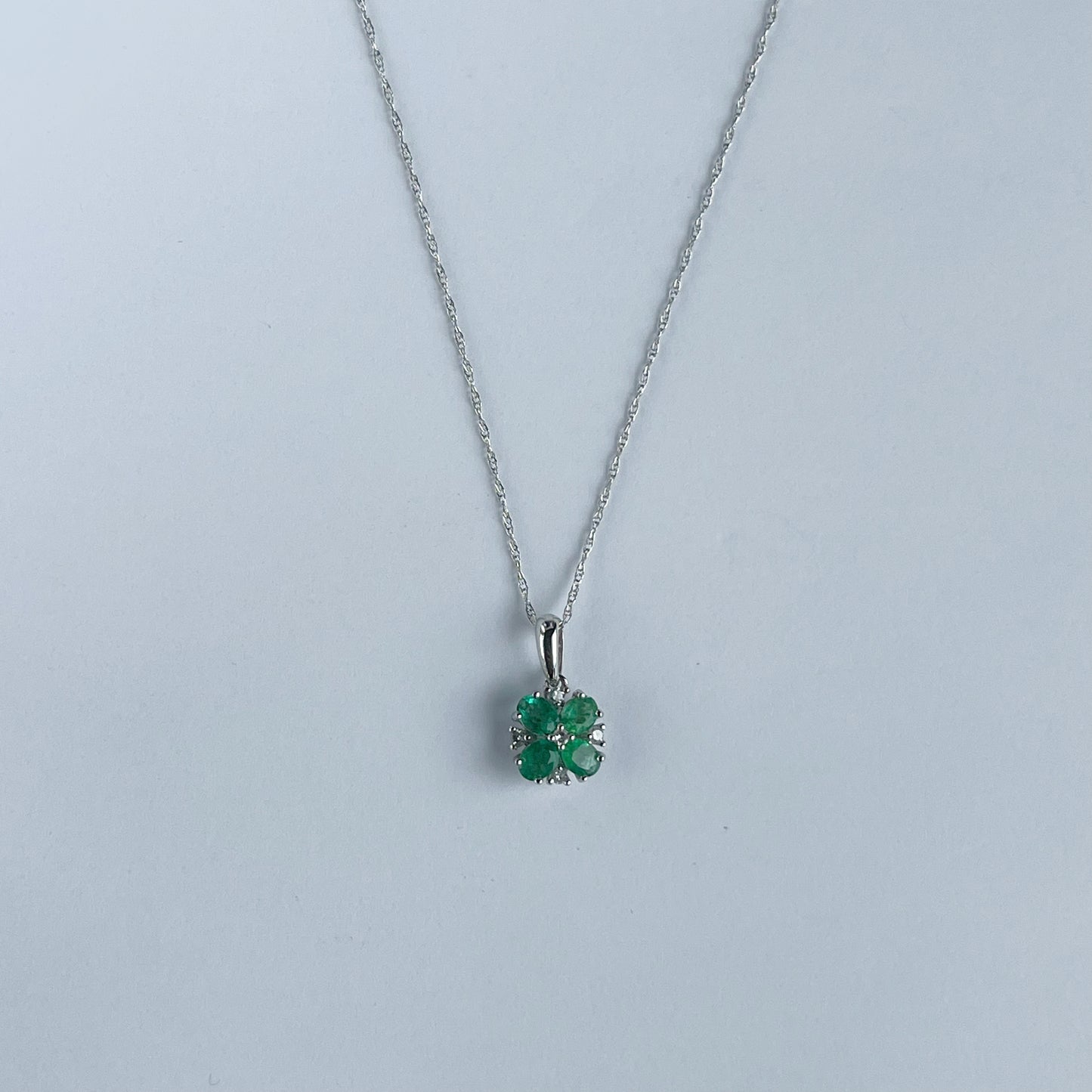 Collar en oro blanco 10k con flor de esmeraldas y diamantes 0.06ct