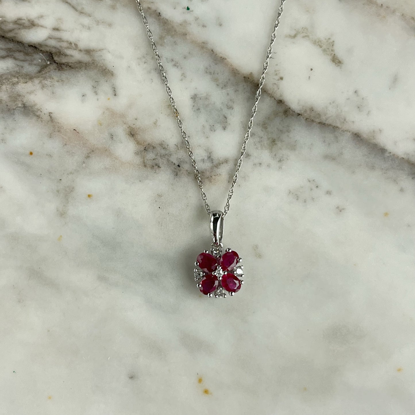 Collar en oro blanco 10k con flor de rubíes y diamantes 0.06ct